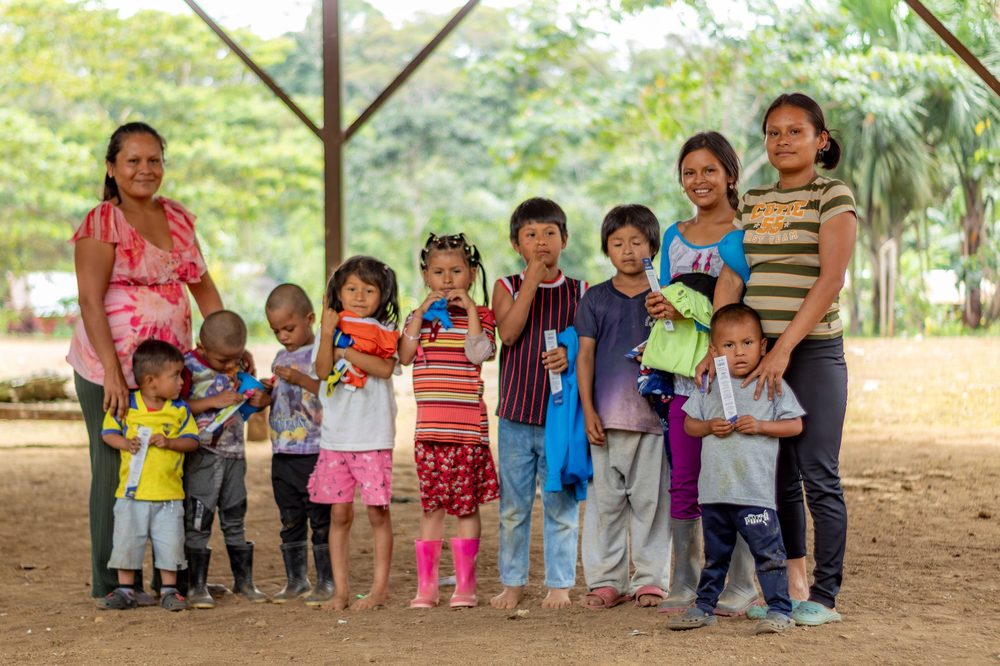 Voluntaria de Suyana Foundation junto a un niño mostrando un dibujo de una cruz